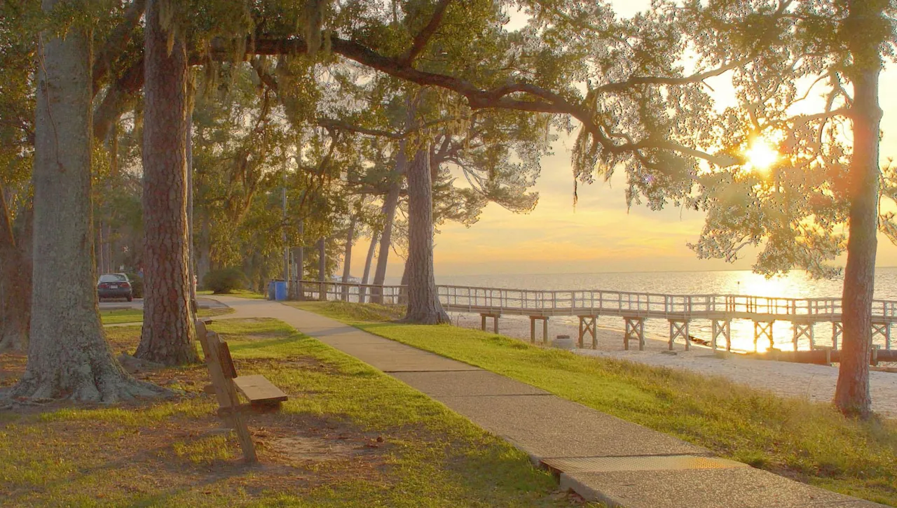 Live oaks and a pier on Mobile Bay at Fairhope in golden light